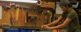 Meg scrapes wax off a pair of Salomon Cross Country Skis. Photo Credit: Jamie Williamson.